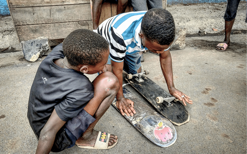 jugendliche-reparieren-skateboard-gemeinsam